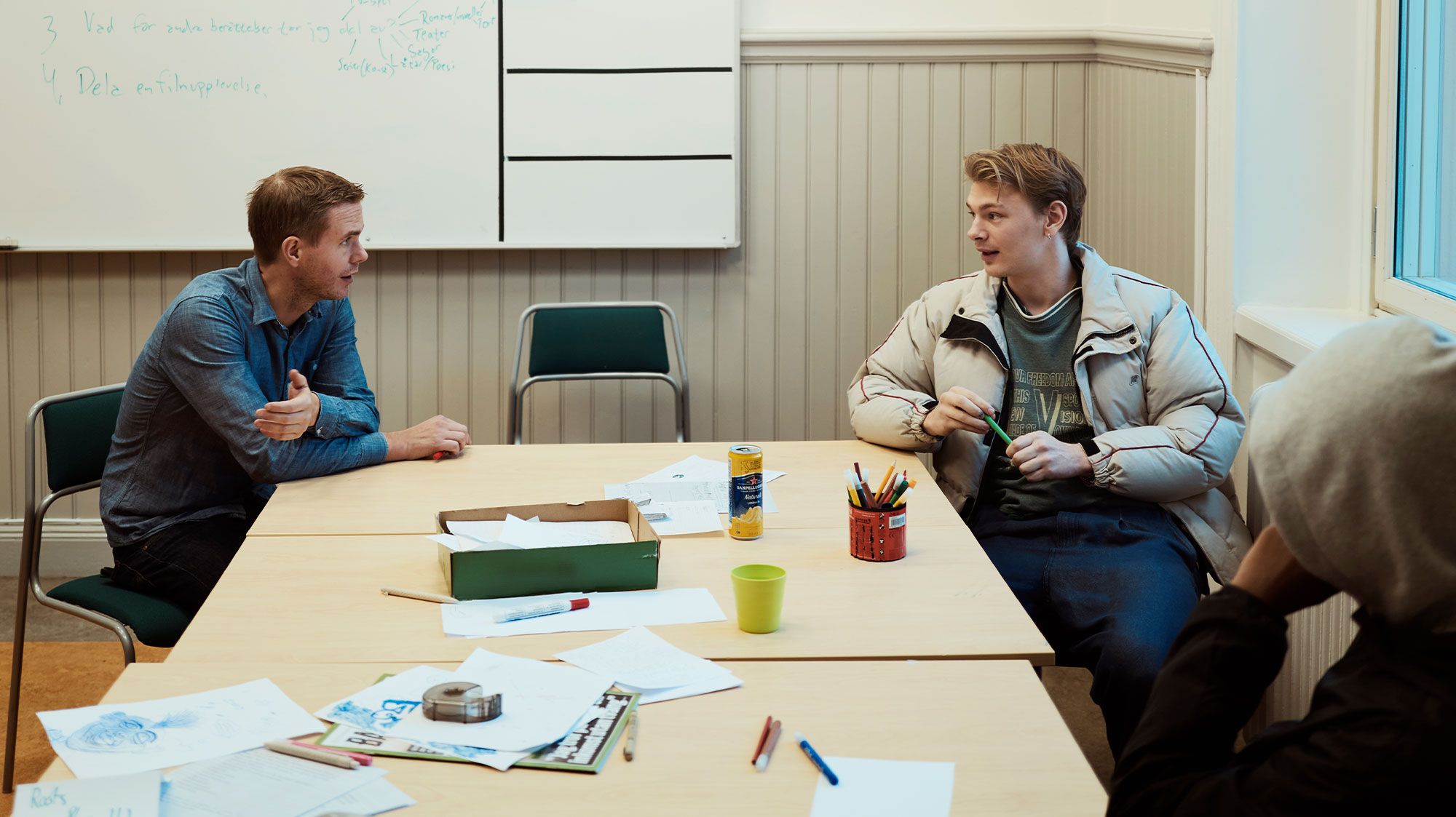 Deltagarna Joar och Yasir i samspråk med sin lärare Gustav Fridolin.