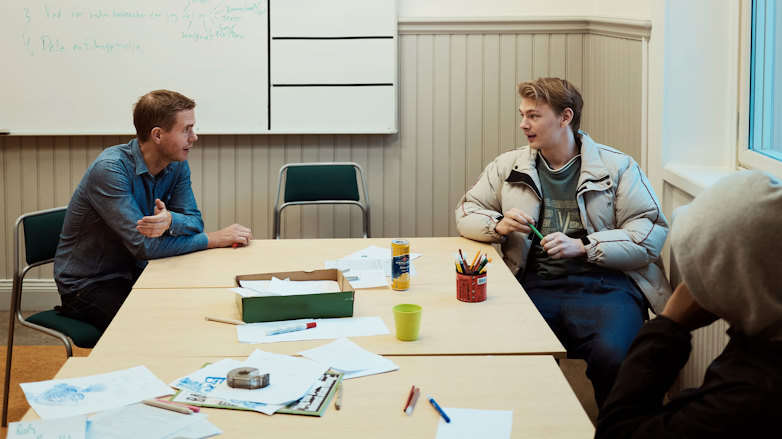 Deltagarna Joar och Yasir i samspråk med sin lärare Gustav Fridolin.