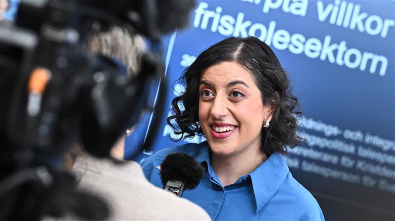 Ett foto av Simona Mohamsson framför reportrarnas mikrofoner vid presskonferensen om friskolornas vinster.