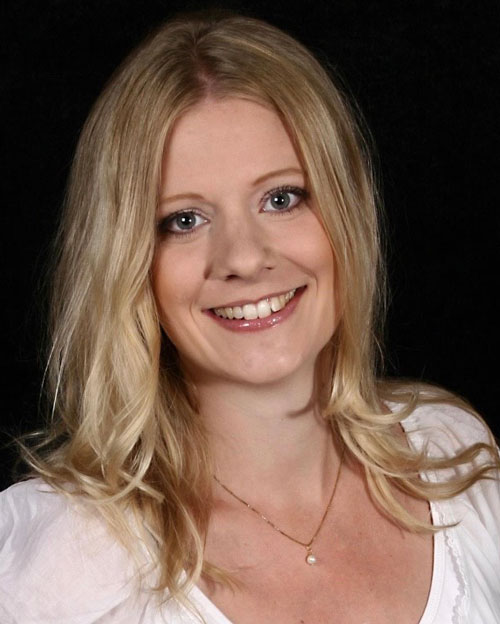 Ett porträtt av Anna Hansson som ler och tittar in i kameran