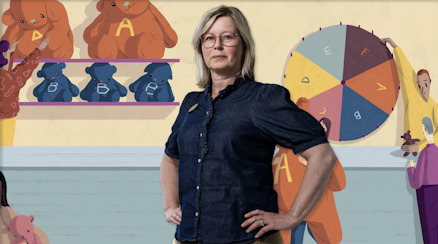 Läraren Cecilia Warnholtz framför en illustration av ”betygslotteriet”.