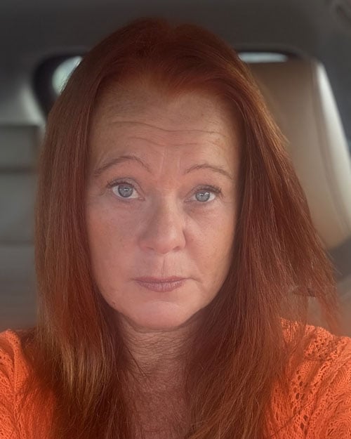 Ett porträtt av Camilla Dannebjörk Gustavsson i orange tröja