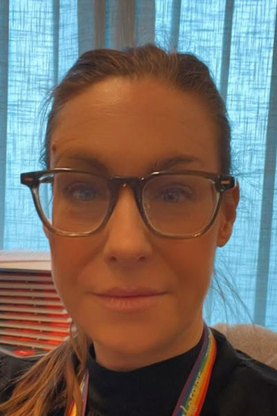 Ett porträtt av Camilla Nyblad med Sveriges Lärares nyckelband i regnbågsfärger om halsen