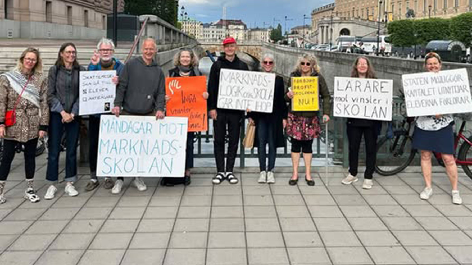 Ett fotografi på en grupp lärare utanför riksdagen i Stockholm, de bär skyltar med kritiska budskap mot vinster i skolan.