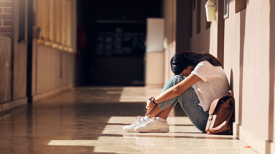 En ensam flicka i tonåren i en korridor