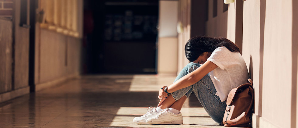 En ensam flicka i tonåren i en korridor