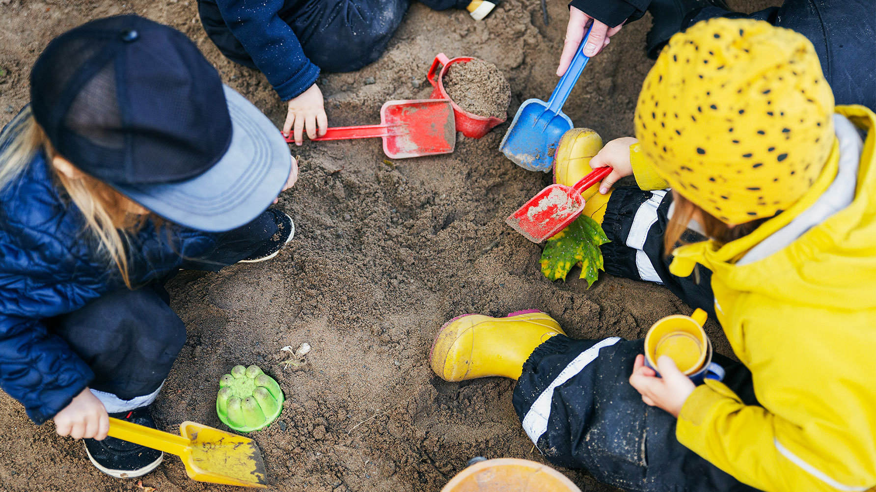 Ett fotografi av lekande barn i en sandlåda