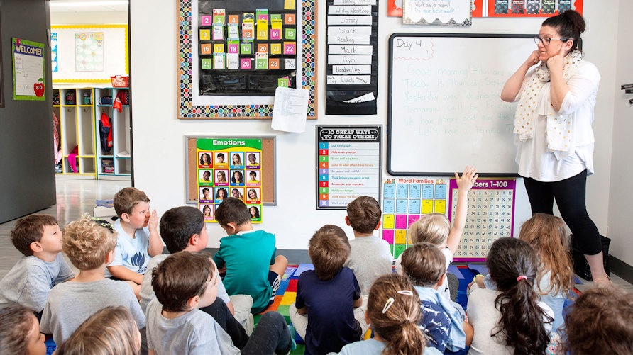 En lärare framför en stor grupp elever