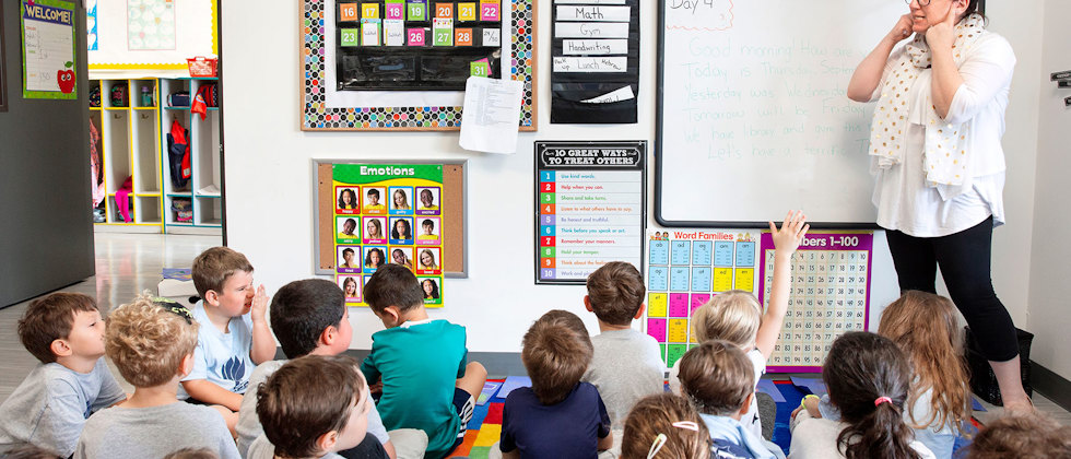 En lärare framför en stor grupp elever