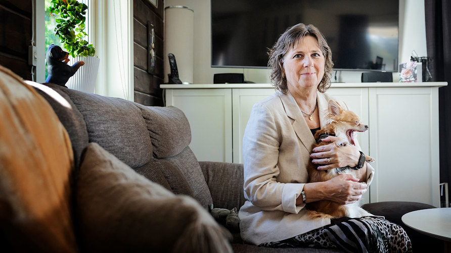 Läraren Inger Österlund, som drabbats av sjukdomen MS, i soffan med chihuahuan Hilma.