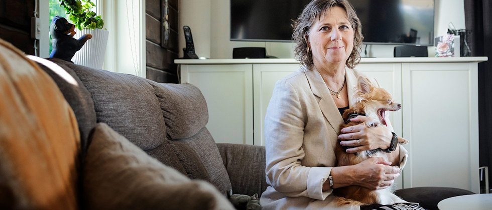 Läraren Inger Österlund, som drabbats av sjukdomen MS, i soffan med chihuahuan Hilma.