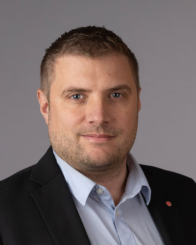 Ett porträtt av Jonas Cronert i kavaj, med Socialdemokraternas partinål