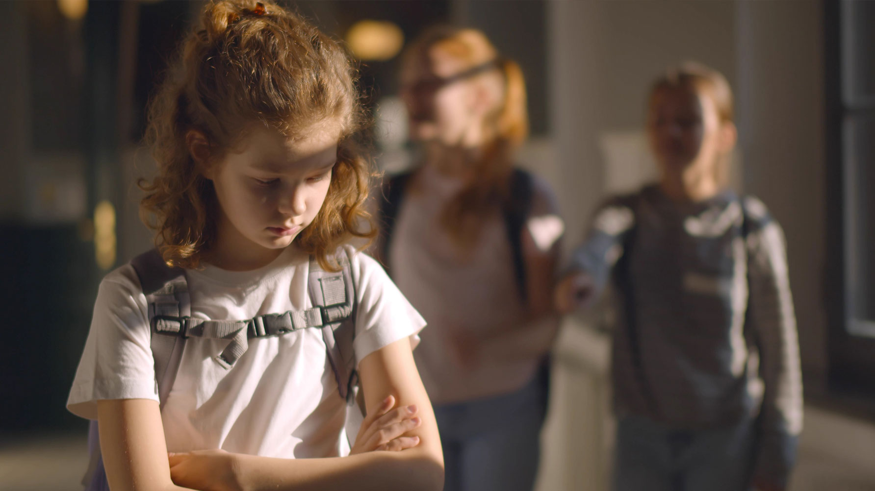 En genrebild av en flicka i en skolkorridor, hon ser ledsen ut