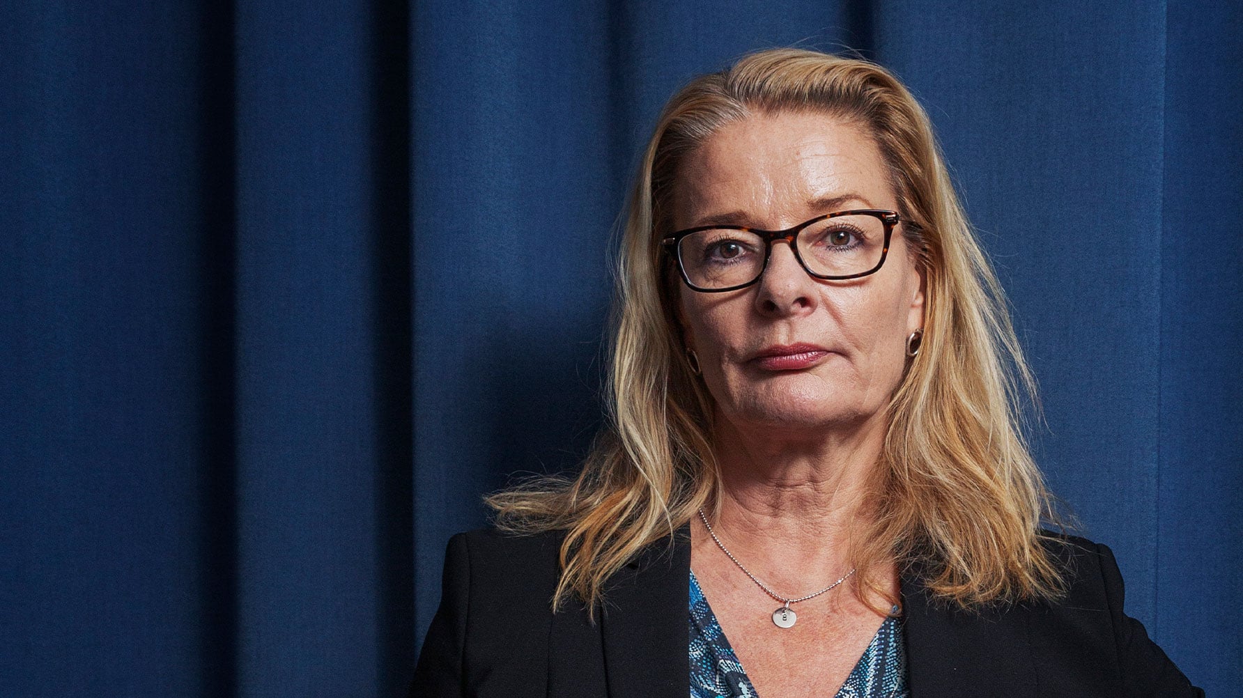 Lotta Edholm mot en blå bakgrund