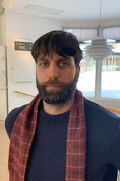 Ett porträtt av Nikolai Almgren som bär en halsduk runt halsen