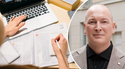 En genrebild av en person som sitter med dator, anteckningar och ett porträtt av Robin Smith