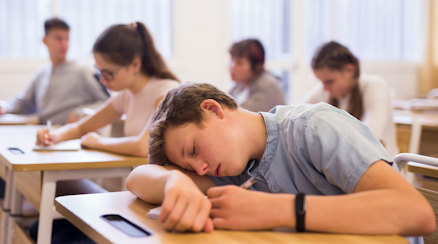 Pojke som sover på skolbänken.