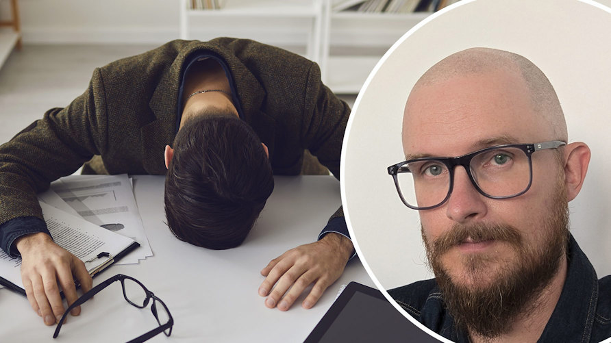 En stressad man som ligger över sitt skrivbord och läraren Mathias Edbäck Leo