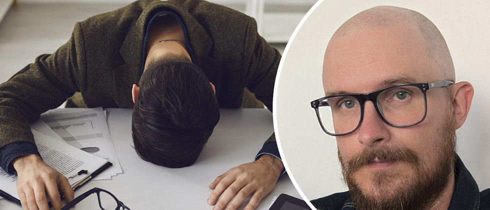 En stressad man som ligger över sitt skrivbord och läraren Mathias Edbäck Leo