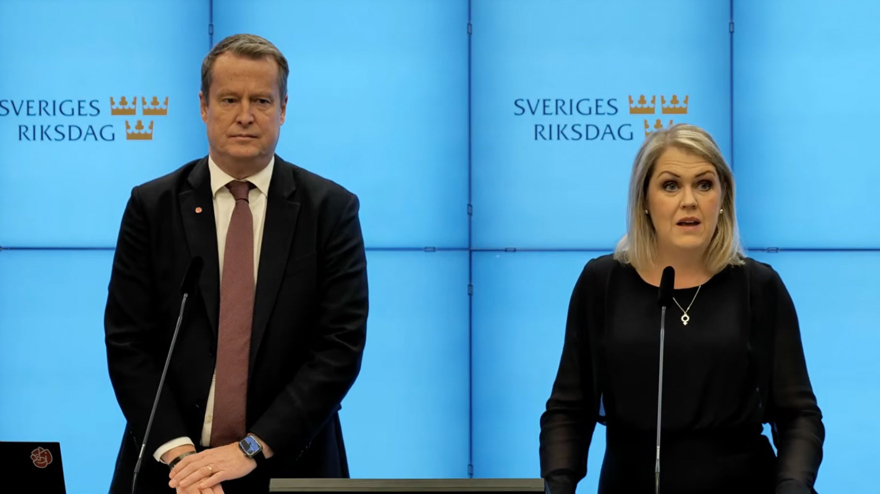 En bild av Anders Ygeman och Lena Hallengren framför varsin mikrofon under presskonferensen