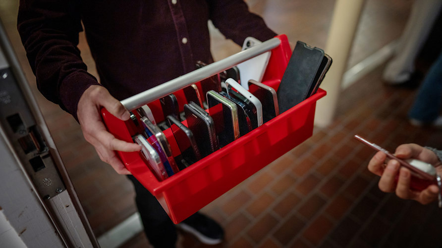 Mobiltelefoner samlas in inför en lektion i ett så kallat mobildagis